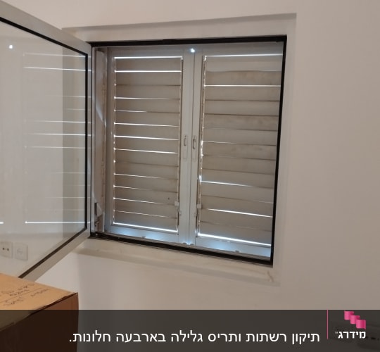 תריסים סגורים בחלון עם מסגרת לבנה